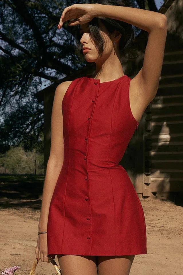 Woman posing in a red sleeveless dress with her arm raised
