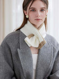 Woman with light brown hair wearing a beige and white striped knit scarf