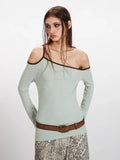 Front view of a model in a light green ribbed knit one-shoulder top, emphasizing the garment's details.