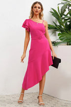 Woman wearing a bright pink one-shoulder dress with an asymmetrical hemline and ruffled sleeve