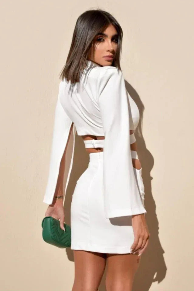 Back view of a woman in a white cut-out crop top and mini skirt set.
