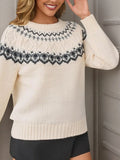 Woman wearing a cream-colored knit sweater with a black and grey Fair Isle pattern, posing with her arm raised.