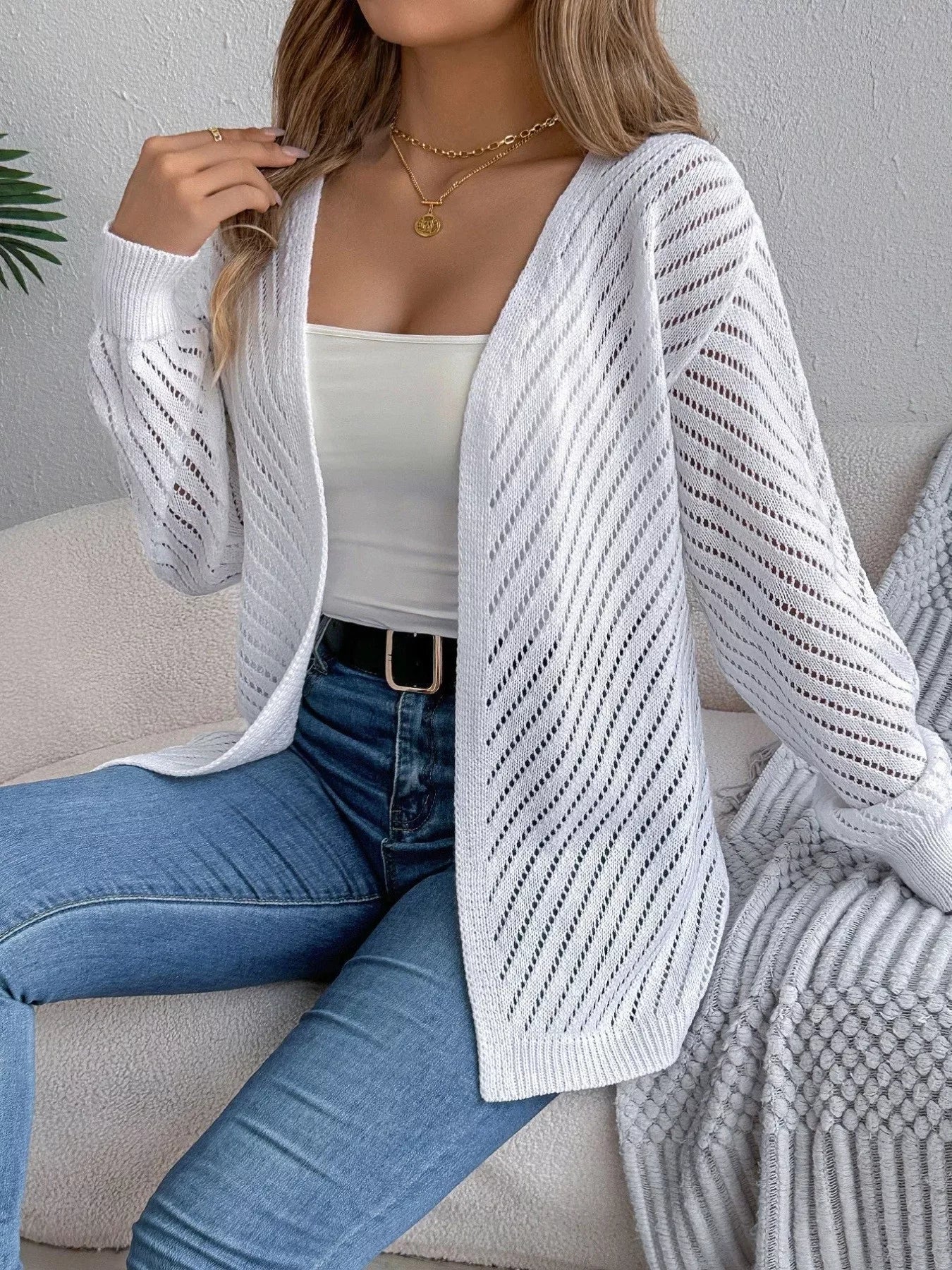 Model styled in a white pointelle knit cardigan with jeans