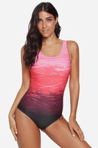 Woman in a pink and red ombre one-piece swimsuit from the front.