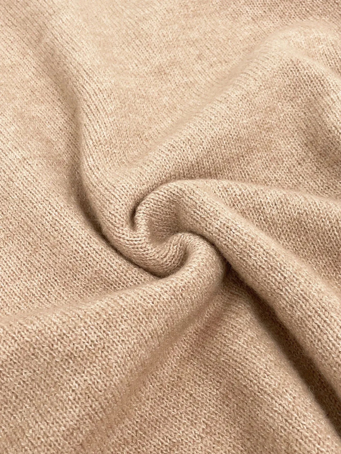 Close-up of beige knit fabric with visible texture.