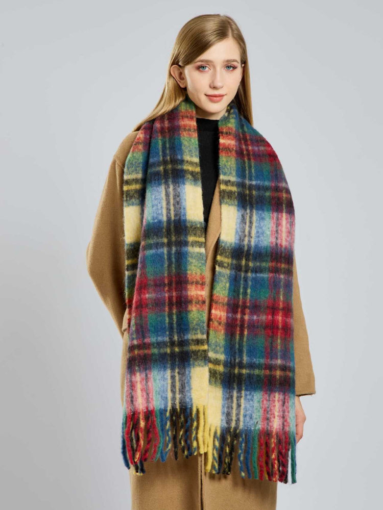 Woman wearing a multicolor plaid scarf with fringe trim
