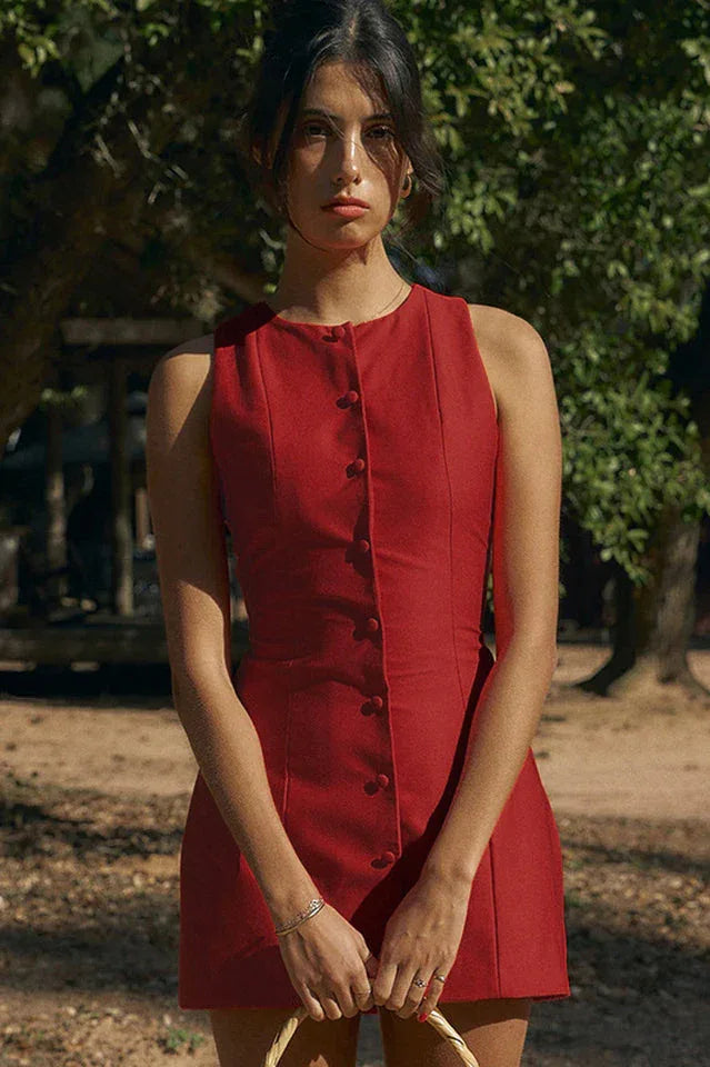Woman wearing a red sleeveless button-front dress outdoors