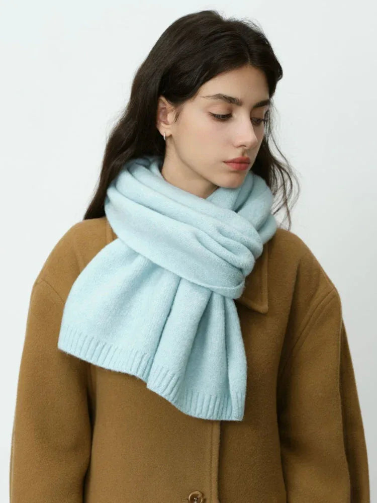 Woman in a camel coat and light blue scarf