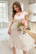 Woman holding a bouquet of flowers while wearing a floral print nightgown