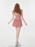 Back view of a woman in a red and white gingham dress
