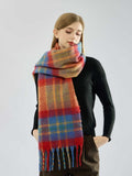 Woman with hands in pockets, wearing a plaid scarf