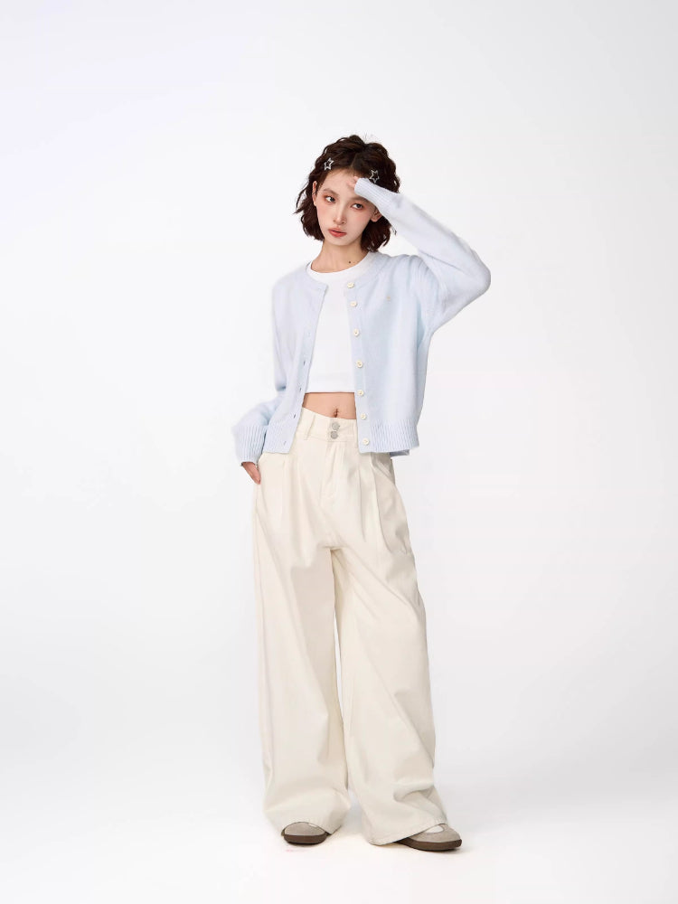 Full body shot of a woman wearing a light blue cropped knit cardigan and cream wide-leg pants.