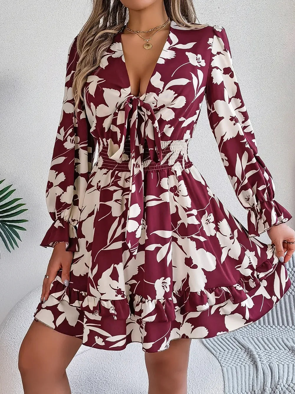 Woman wearing a burgundy floral tie-front mini dress