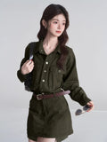 Full body shot of a woman in an olive green belted dress.