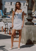 Woman wearing a blue and white striped mini dress with puff sleeves and lace trim outdoors.