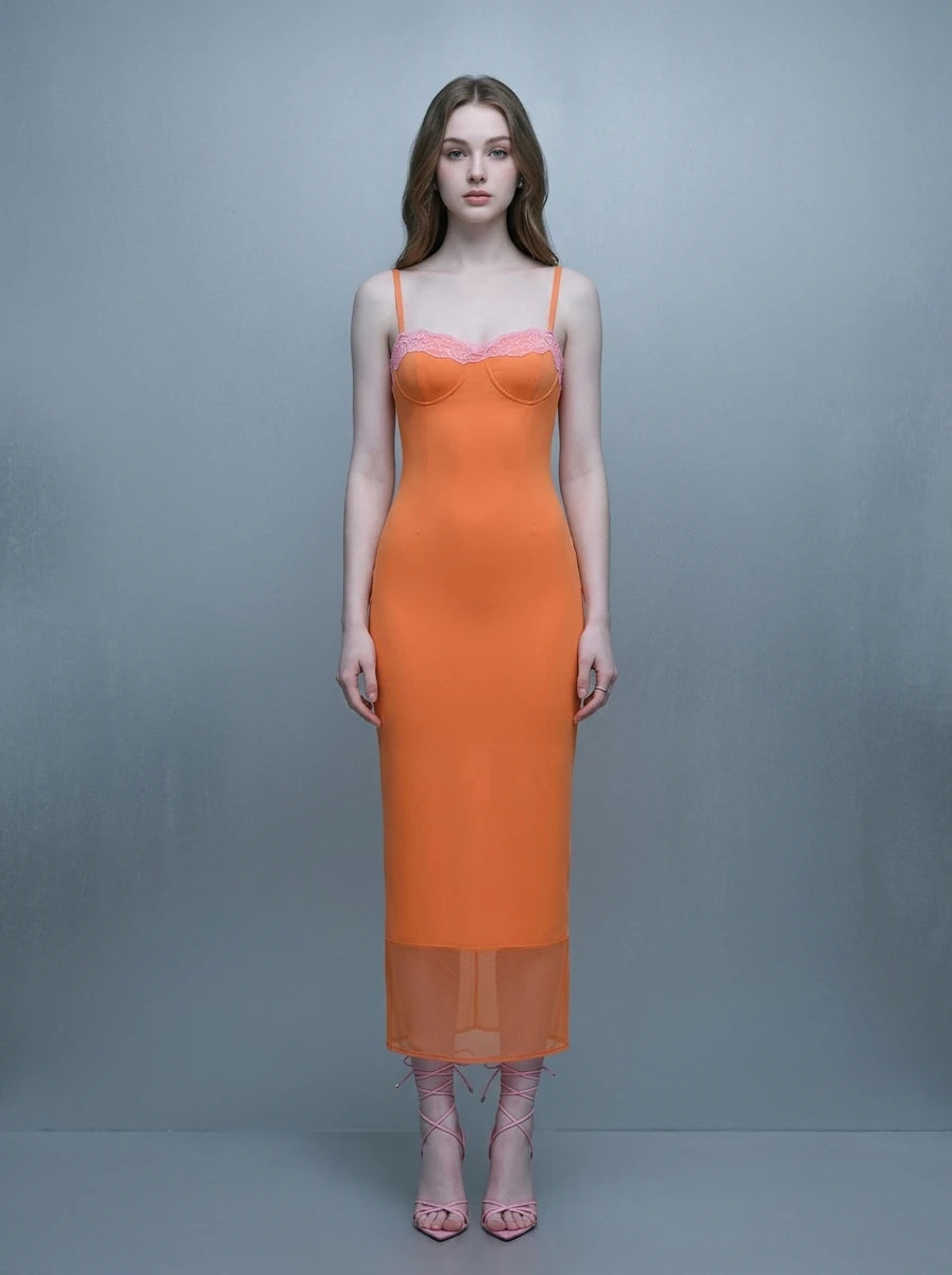 Woman wearing an orange slip dress with pink lace trim and spaghetti straps.
