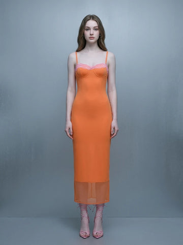 Woman wearing an orange slip dress with pink lace trim and spaghetti straps.