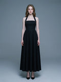 woman wearing a black midi halter dress with a square neckline