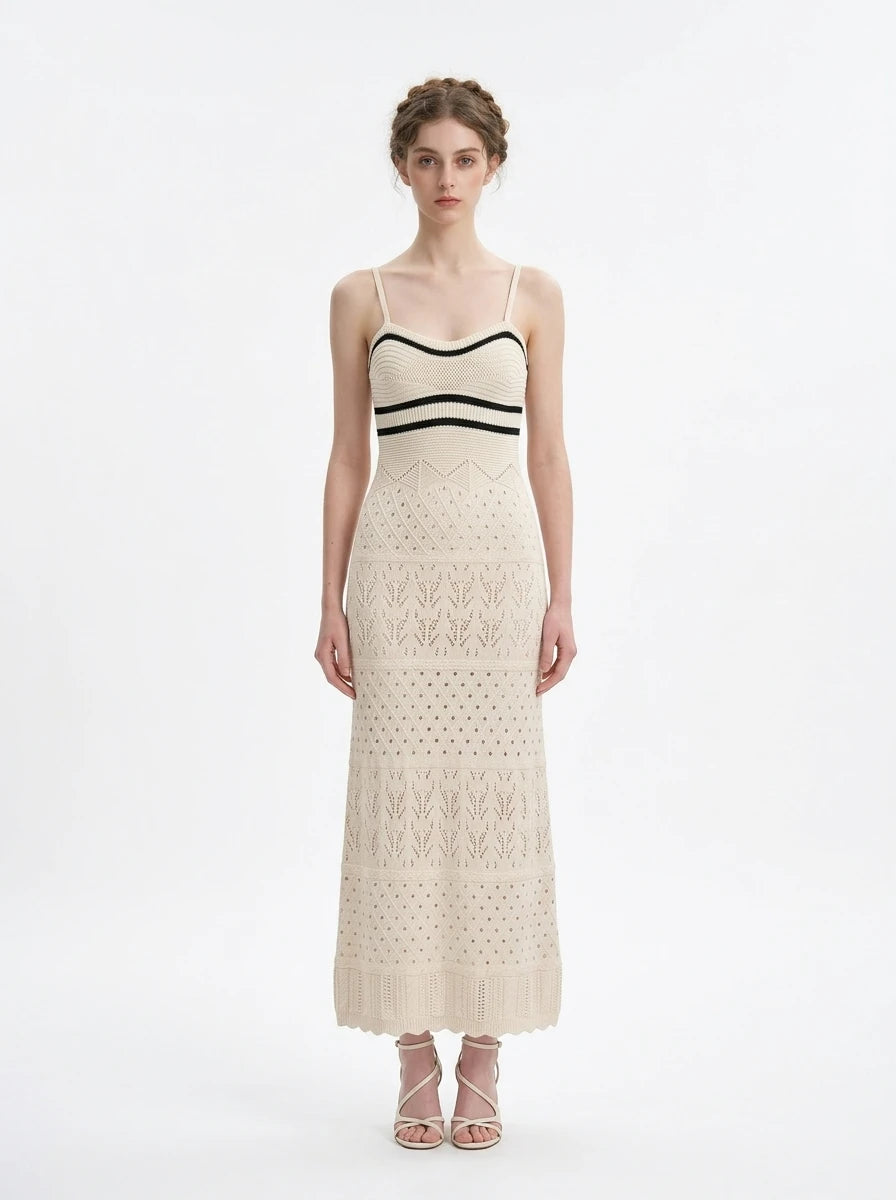 Woman wearing a cream knit maxi dress with black striped bodice and spaghetti straps, front view