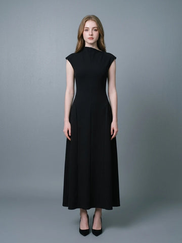 Woman wearing a sleeveless black A-line midi dress with a mock neck.
