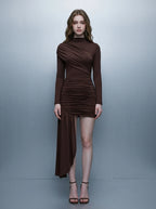 Model wearing a long-sleeved brown ruched mini dress with an asymmetrical hemline and high neckline, front view