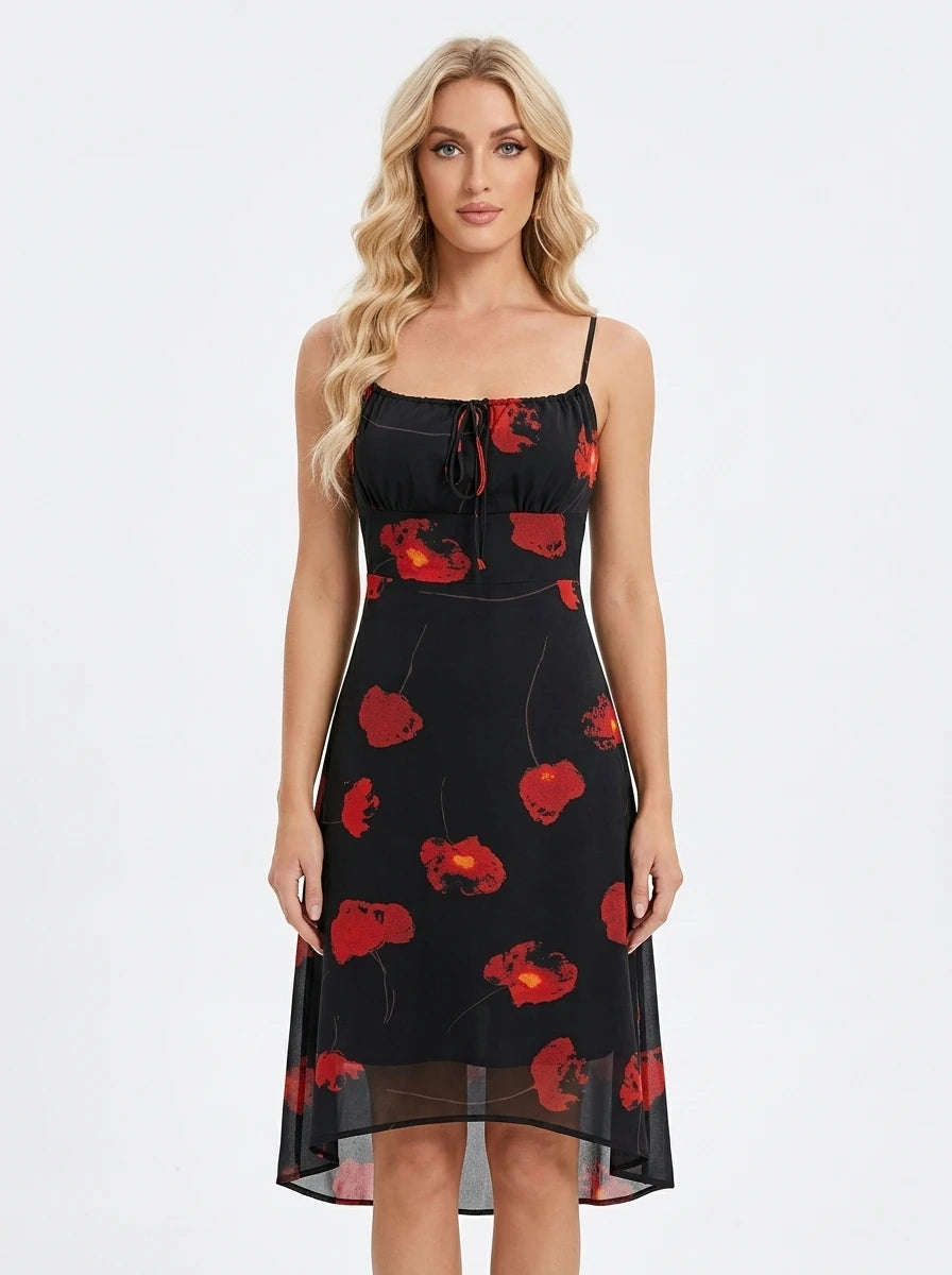 Woman wearing a black midi dress with a red floral print, spaghetti straps, and a tie-front bodice
