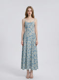 Woman wearing a light blue floral print midi dress with spaghetti straps