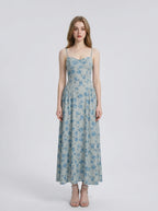 Woman wearing a light blue floral print midi dress with spaghetti straps