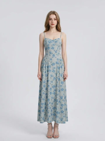 Woman wearing a light blue floral print midi dress with spaghetti straps