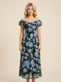 Woman wearing a black floral print off-the-shoulder midi dress with blue flowers and ruffle trim