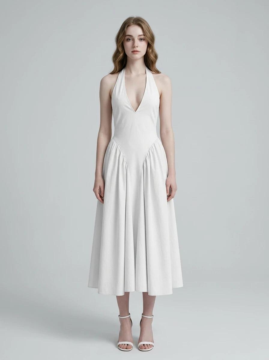 Woman wearing a white halter neck midi dress with a V-neckline and flared skirt.