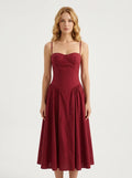 Woman wearing a deep red linen blend midi dress with spaghetti straps and a sweetheart neckline