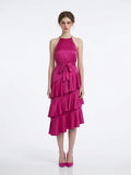 Woman wearing a fuchsia satin halter neck tiered midi dress with a self-tie belt