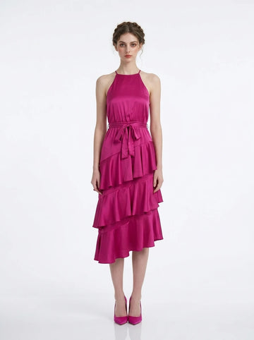 Woman wearing a fuchsia satin halter neck tiered midi dress with a self-tie belt