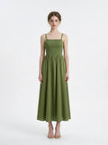 Woman wearing a green linen blend midi dress with a smocked bodice and spaghetti straps, front view.
