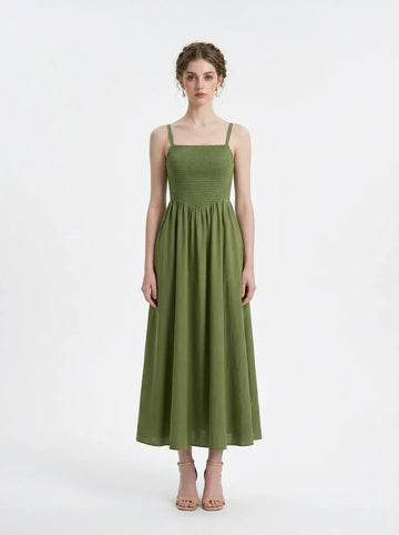 Woman wearing a green linen blend midi dress with a smocked bodice and spaghetti straps, front view.