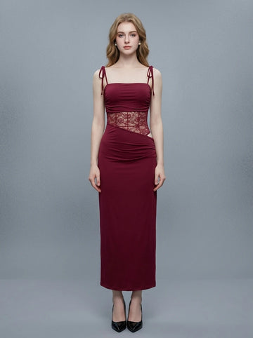 Woman wearing a long burgundy dress with a square neckline and lace detailing on the bodice.
