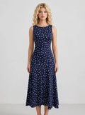 Woman wearing a navy blue polka dot midi dress