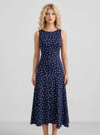 Woman wearing a navy blue polka dot midi dress