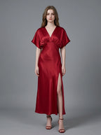 Woman in a red satin V-neck dress with kimono sleeves and a high slit, front view