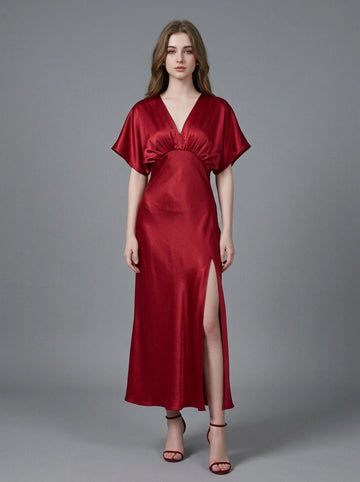 Woman in a red satin V-neck dress with kimono sleeves and a high slit, front view