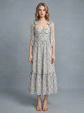 Woman wearing a floral print midi dress with tie shoulder straps and a ruched bodice