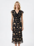 Woman wearing a black floral print midi dress with flutter sleeves and lace trim.