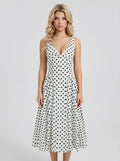 Woman wearing a white sleeveless V-neck dress with black polka dots