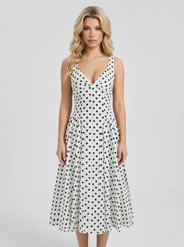 Woman wearing a white sleeveless V-neck dress with black polka dots