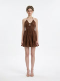 Woman wearing a brown halter neck tiered mini dress