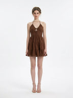 Woman wearing a brown halter neck tiered mini dress