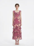 Woman wearing a floral print chiffon maxi dress with ruffled neckline and tiered skirt