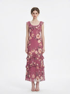 Woman wearing a floral print chiffon maxi dress with ruffled neckline and tiered skirt