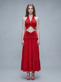 Woman wearing a red halter neck crop top and a tiered maxi skirt.
